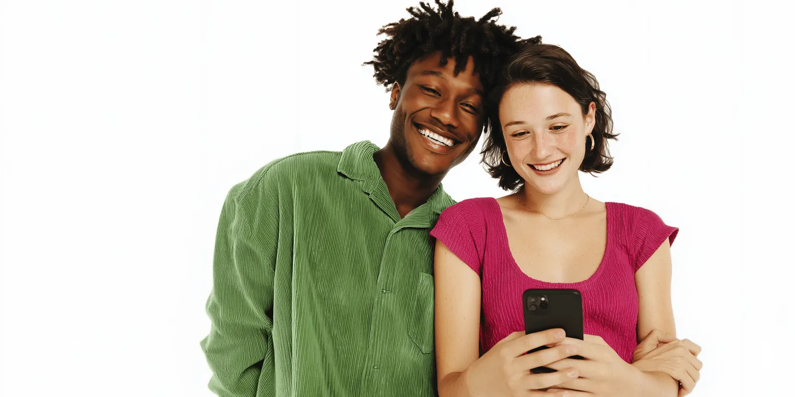 Man in a green corduroy shirt and a woman in pink studying her phone together on a white background, viewers judging an ad in a second