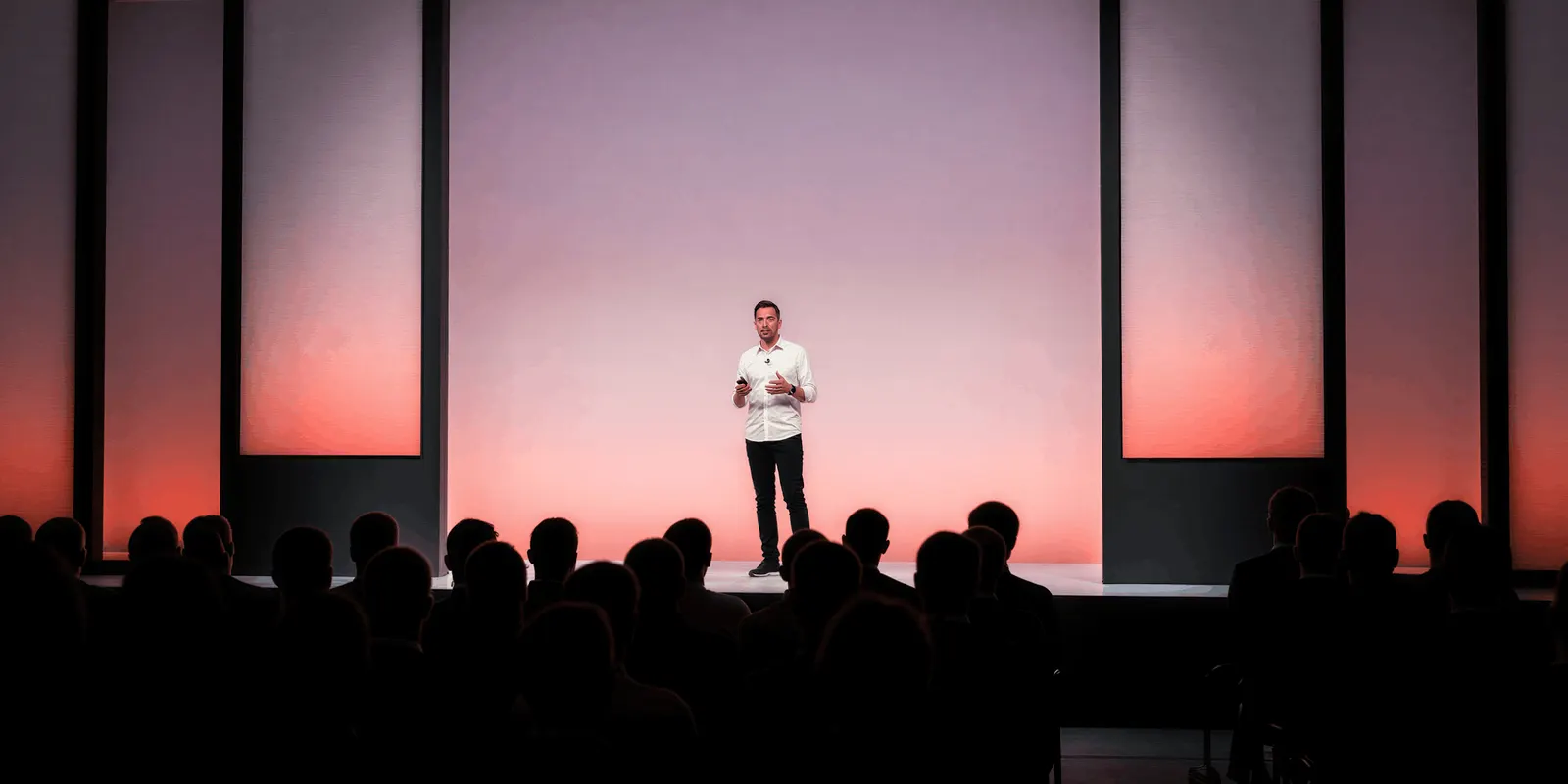 Man in a white shirt speaks to an audience on a large stage, the ideas and judgment that stay with a person
