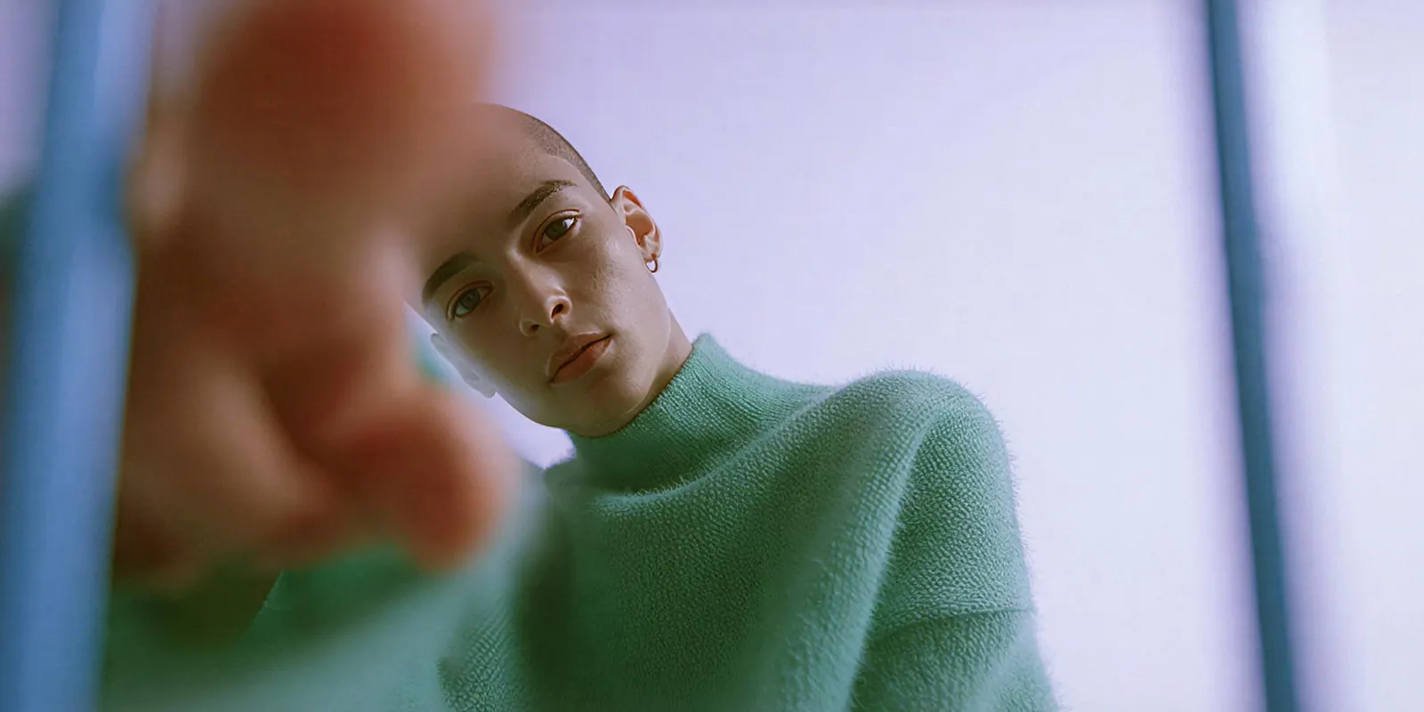 Person in a mint green mock-neck knit sweater reaching toward the camera, the fuzzy yarn surface a recolor has to keep