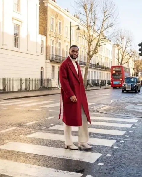 A still from a DesignerBox video: a man in a red coat on the same street