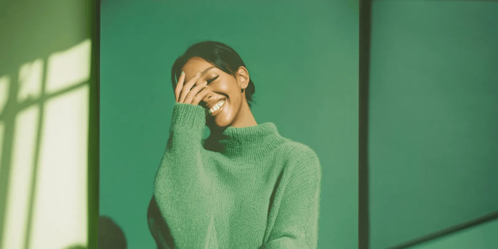 Woman in a green knit sweater smiles against a green wall, a single color of a garment that needs its own images