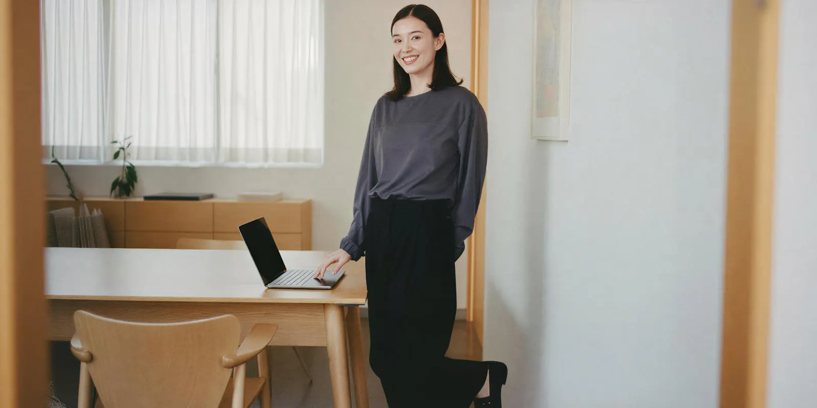 Woman stands at a desk with a hand on an open laptop, checking a catalog file before the same fault spreads