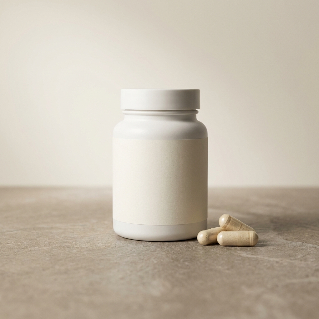 White supplement bottle on a stone counter with three capsules resting beside it